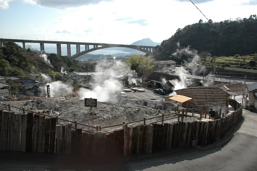 湯けむりが立ち上っている明礬の湯の花小屋の写真